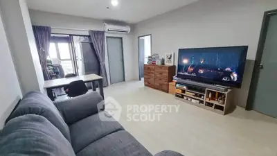 Spacious living room with modern decor and large TV, perfect for relaxation and entertainment.