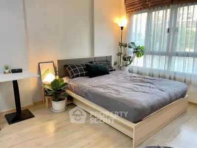 Cozy bedroom with modern decor, large window, and natural light