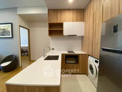 Modern kitchen with sleek wooden cabinetry, integrated appliances, and a washing machine for convenience.