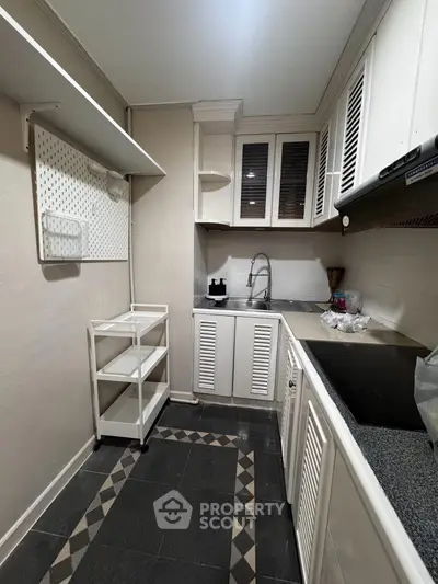 Charming compact kitchen with modern cabinetry and sleek countertops, perfect for efficient cooking in a cozy space.