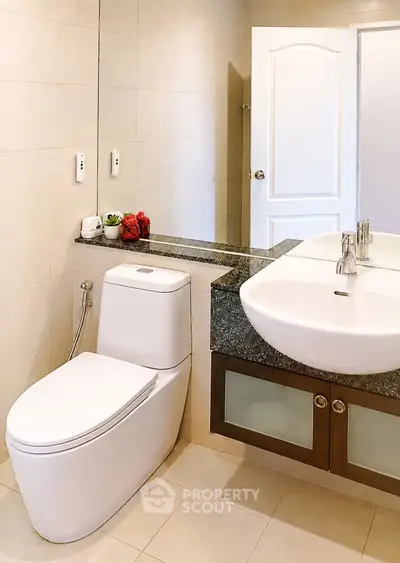 Modern bathroom with sleek fixtures and elegant design, featuring a stylish sink and toilet.