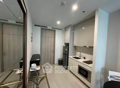 Modern compact kitchen with sleek cabinetry and built-in appliances in a stylish apartment.