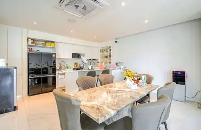 Modern kitchen with marble dining table and sleek appliances in a bright open space.