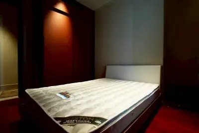 Spacious bedroom with modern design and comfortable mattress in a cozy setting.