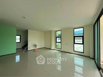 Spacious modern living room with large windows and natural light