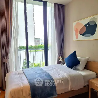 Cozy bedroom with modern decor and large window offering a serene view, perfect for relaxation.