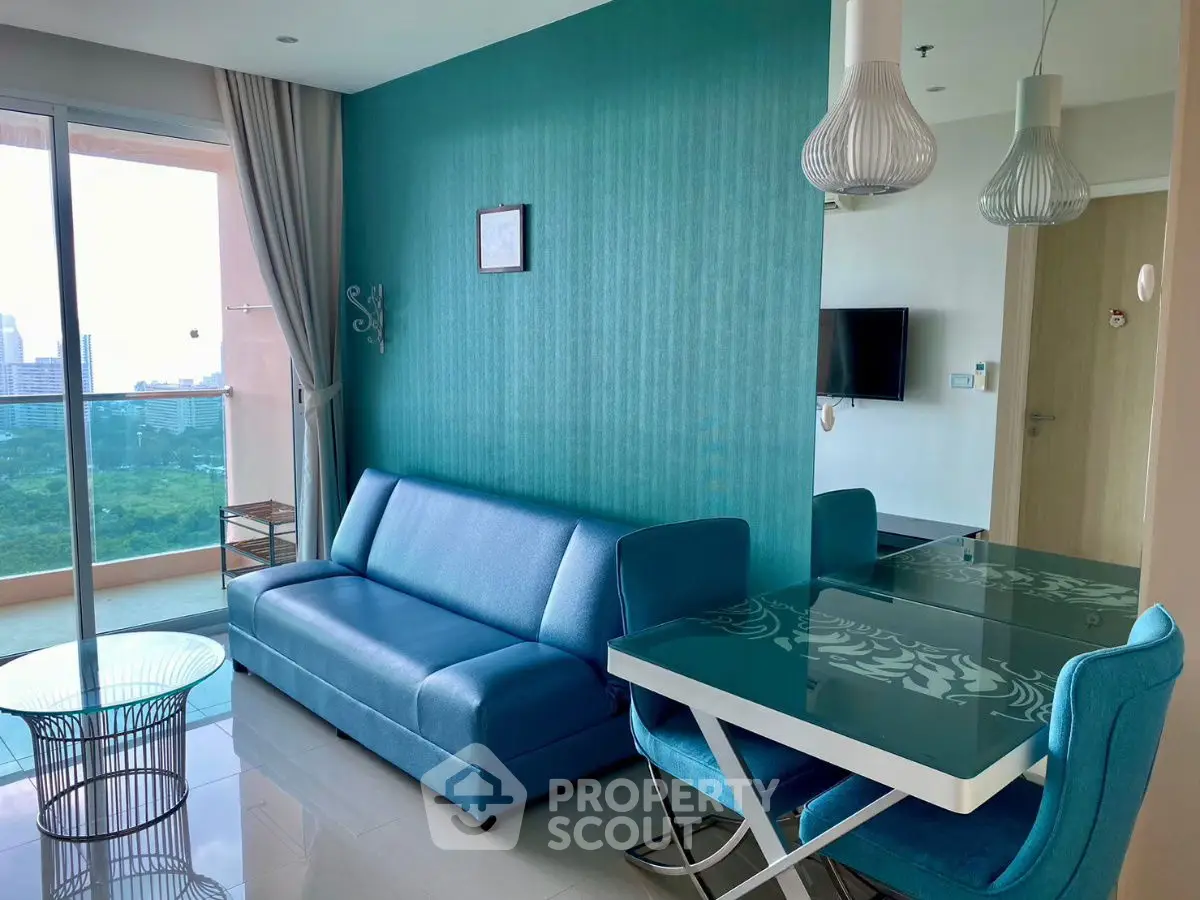 Modern living room with teal accents, stylish furniture, and a view of the city skyline.