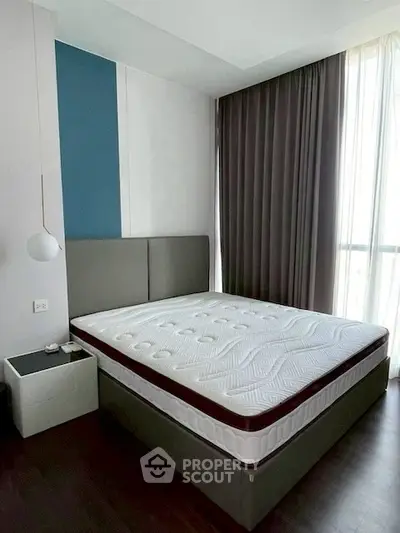 Modern bedroom with stylish decor and large window for natural light