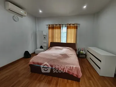 Spacious bedroom with wooden flooring and modern furnishings