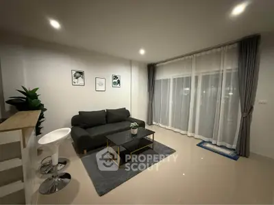 Modern living room with sleek furniture and large windows for natural light.