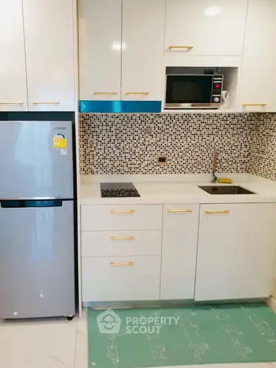 Modern compact kitchen with sleek appliances and stylish backsplash