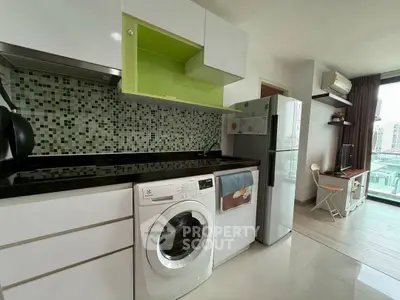 Modern kitchen with washing machine and fridge in open layout apartment