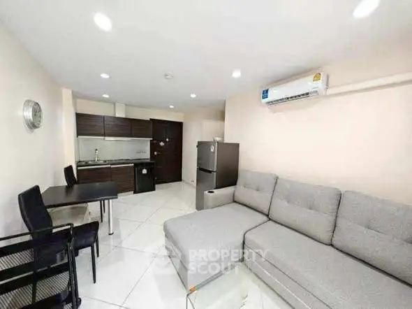 Modern living room with sleek kitchen and stylish furniture in open layout apartment.