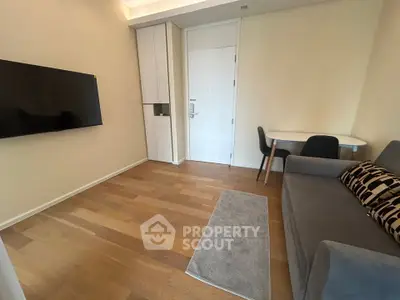Modern living room with sleek furniture and wall-mounted TV in a cozy apartment.