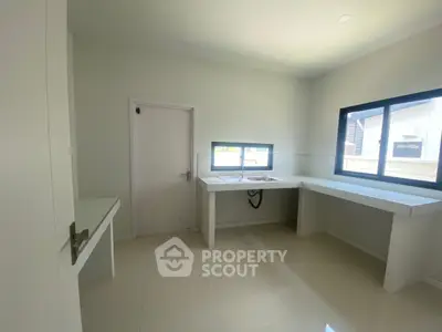 Spacious modern kitchen with sleek countertops and ample natural light.