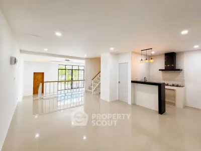 Spacious open-plan living area with modern kitchen and elegant lighting
