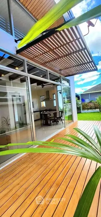 Modern home with open layout and lush garden view, featuring sleek wooden accents and expansive glass doors.