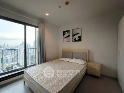 Modern bedroom with city view and stylish decor in high-rise apartment.