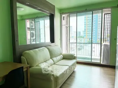 Bright living room with green walls, cozy sofa, and balcony view in modern apartment.