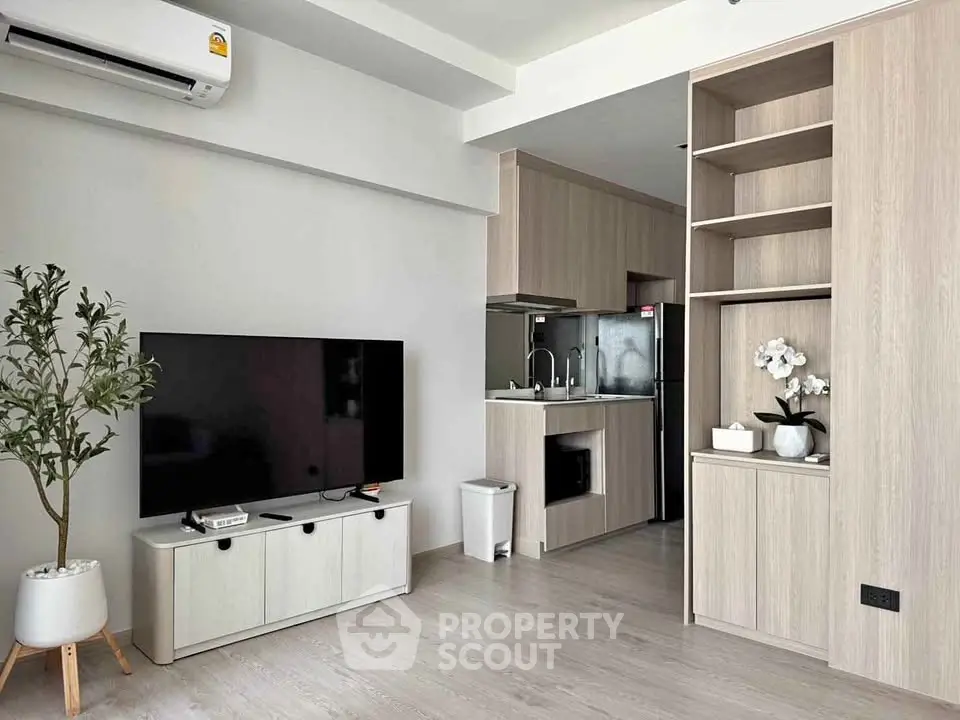 Modern living room with sleek TV setup and open kitchen design