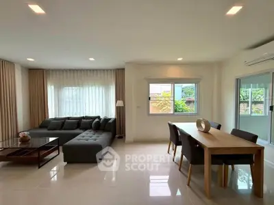 Spacious modern living room with large windows and elegant dining area