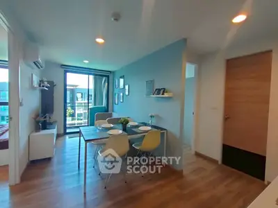 Modern open-plan living room with dining area and balcony view in stylish apartment.
