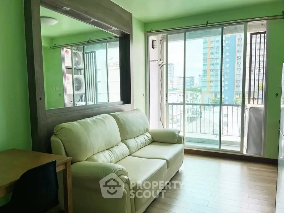 Bright living room with green walls, cozy sofa, and balcony view in modern apartment.