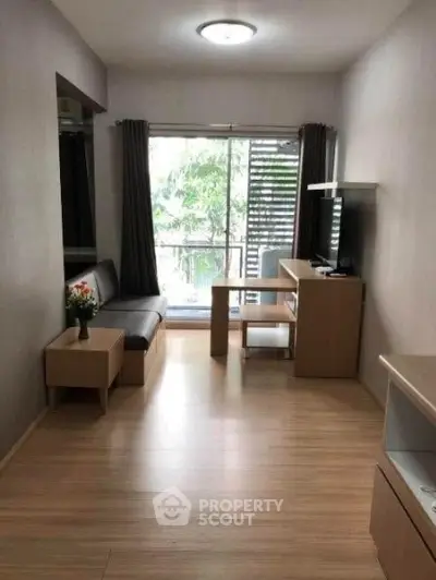 Modern living room with wooden flooring and large window offering natural light.