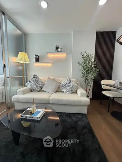 Modern living room with cozy sofa, stylish decor, and elegant lighting