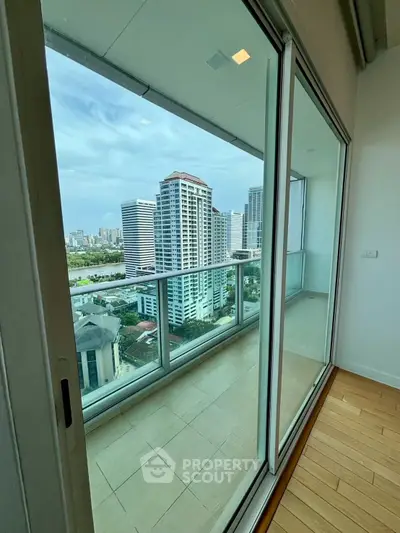 Stunning high-rise balcony view with cityscape and modern glass doors.