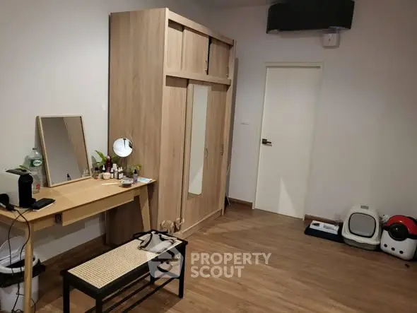 Spacious bedroom with wooden flooring and modern furniture