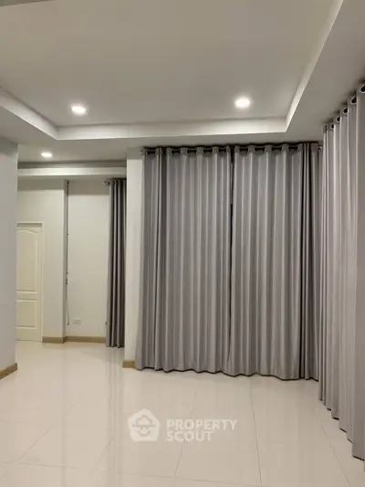 Spacious living room with elegant curtains and modern lighting