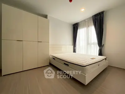 Modern bedroom with minimalist design, featuring a large wardrobe and natural light.
