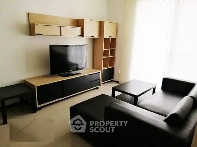 Modern living room with sleek black furniture and wall-mounted TV unit, perfect for stylish urban living.