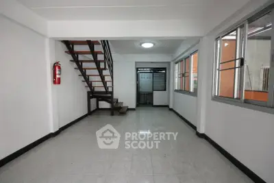 Spacious interior with modern staircase and large windows, ideal for versatile living space.