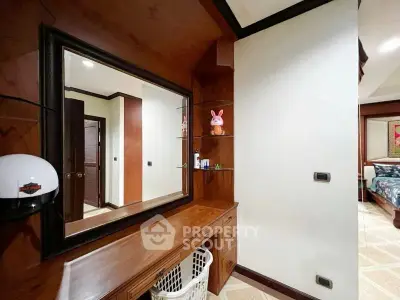 Elegant bedroom with wooden accents and large mirror, showcasing cozy and stylish interior design.