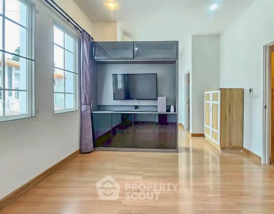 Spacious living room with modern entertainment center and large windows