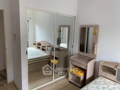 Spacious bedroom with mirrored closet and modern wooden furniture