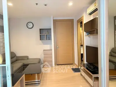 Modern living room with sleek furniture and wall-mounted TV in a cozy apartment setting.