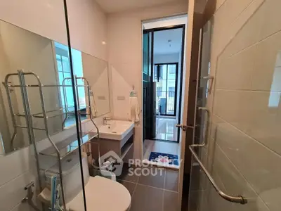 Modern bathroom with sleek fixtures and large mirror in a contemporary apartment.