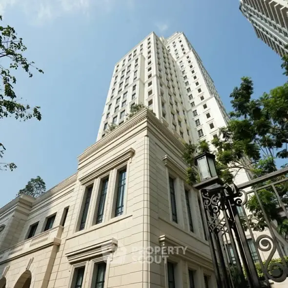 Elegant high-rise building with classic architecture and lush greenery, perfect for luxury urban living.