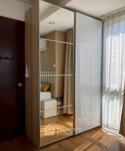 Modern bedroom with mirrored wardrobe and natural light