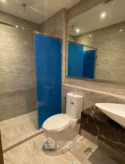 Modern bathroom with sleek design and elegant fixtures, featuring a glass shower and stylish vanity.