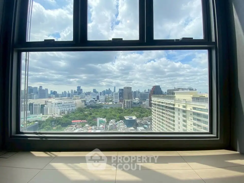Stunning cityscape view from a high-rise window, showcasing urban skyline and blue skies.
