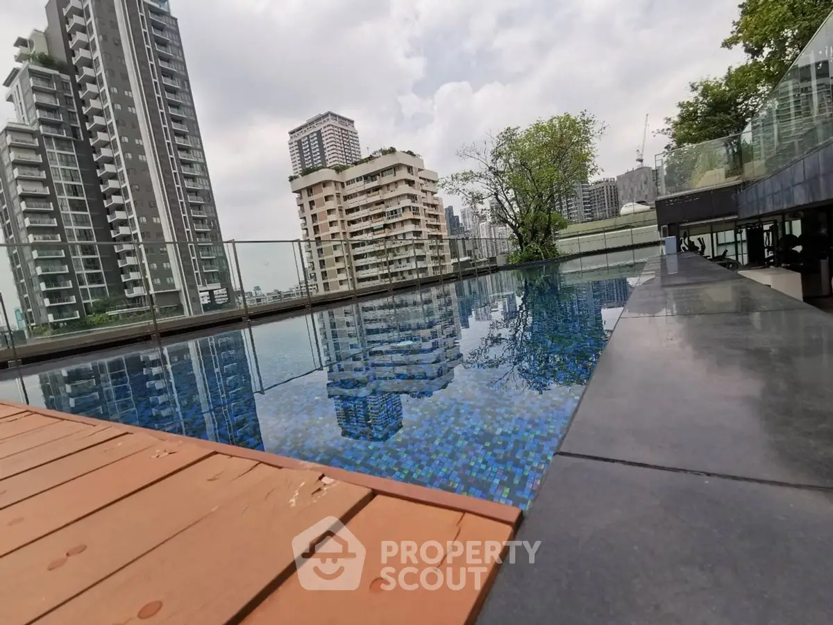 Luxurious rooftop pool with stunning city skyline views in modern high-rise building.