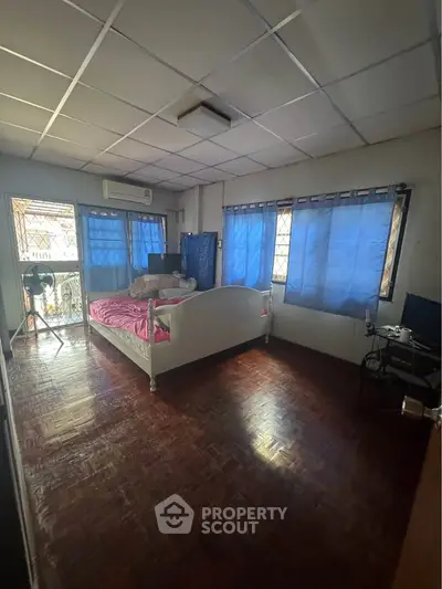 Cozy bedroom with natural light and wooden flooring