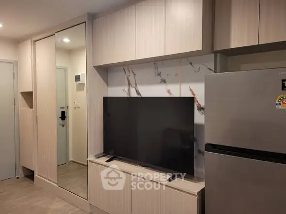 Modern apartment interior with sleek cabinetry and large flat-screen TV