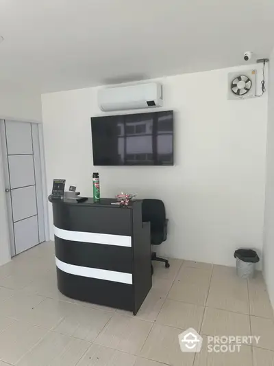 Modern office reception area with sleek desk and wall-mounted TV