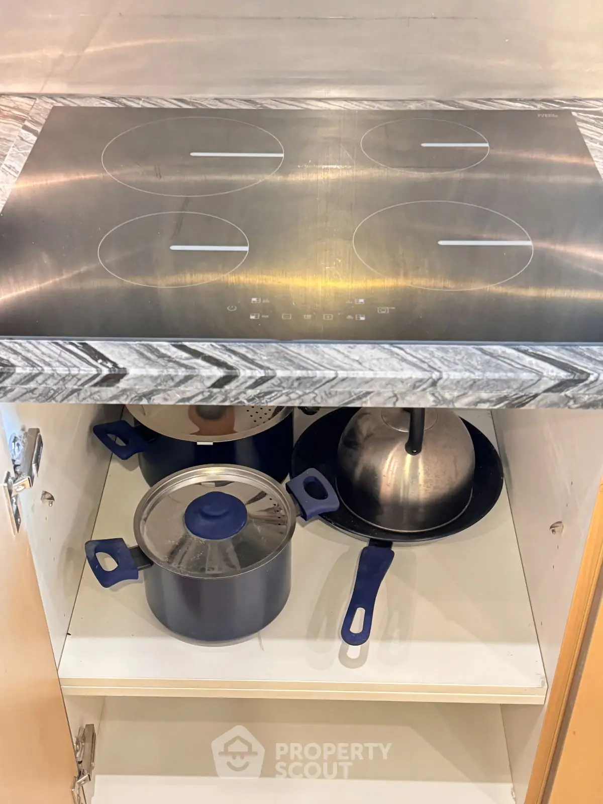 Modern kitchen with sleek induction cooktop and organized storage space.