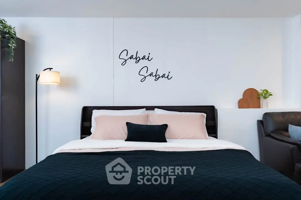 Modern bedroom with stylish decor and cozy bedding in a contemporary apartment.